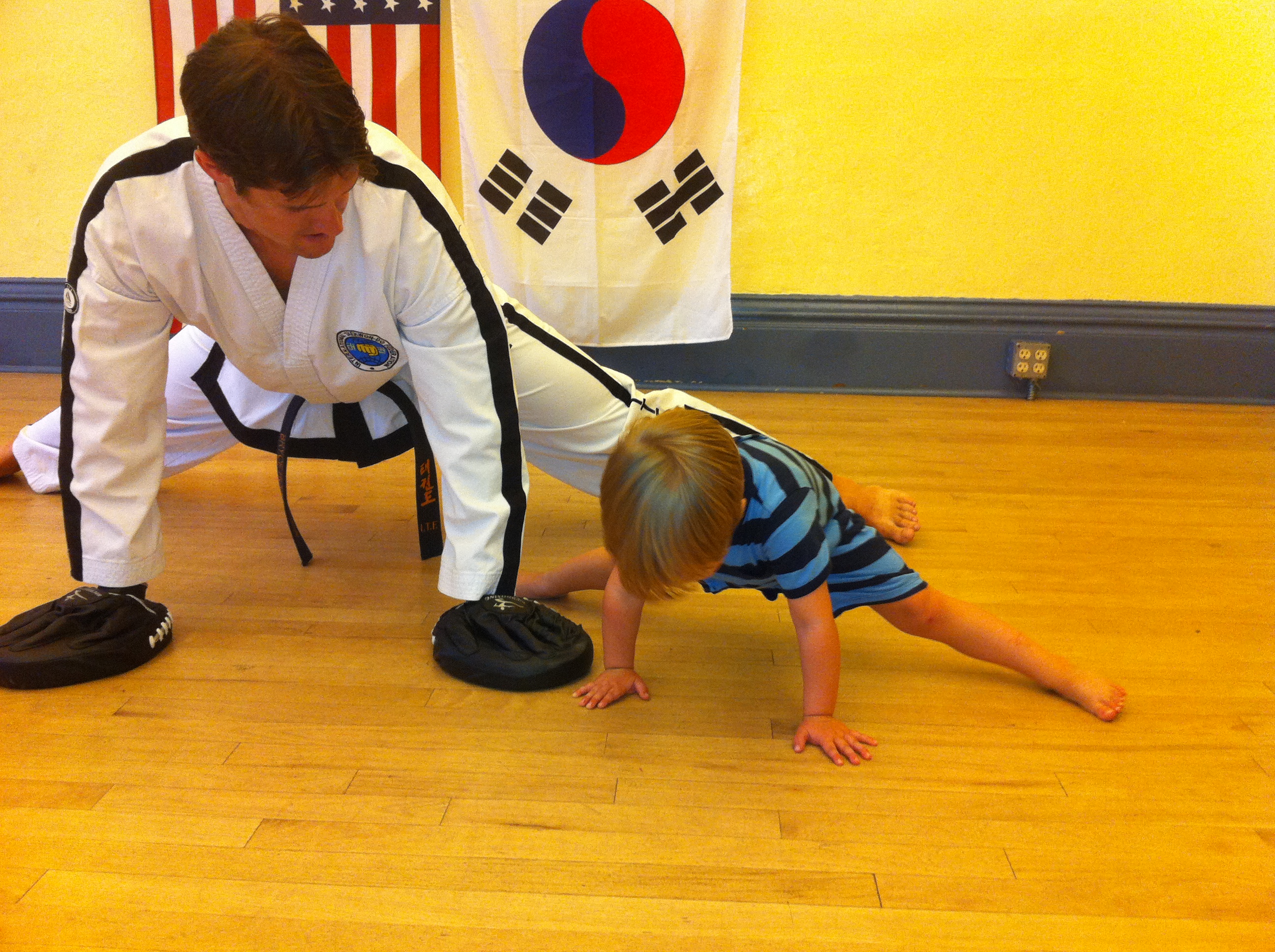 Instructor with child in dobok — family martial arts training